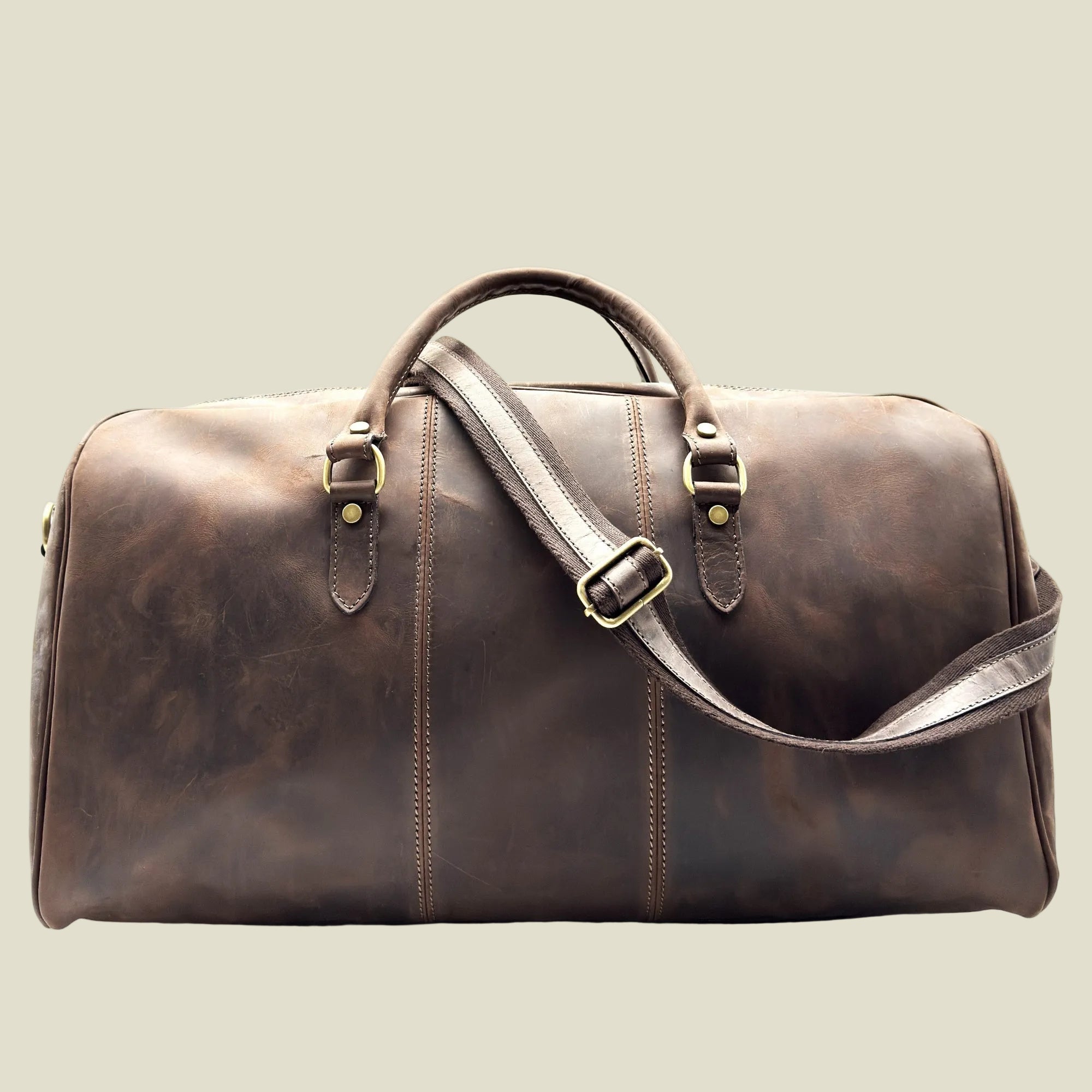 A dark brown distressed leather duffel bag with double top handles, a detachable shoulder strap, and brass-tone hardware, shown against a plain white background.