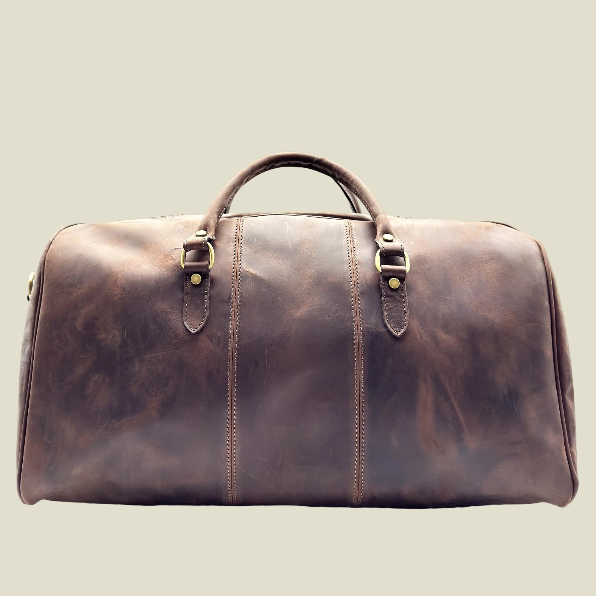 A brown distressed leather duffel bag with dual top handles and brass-tone buckle details, shown against a plain white background.