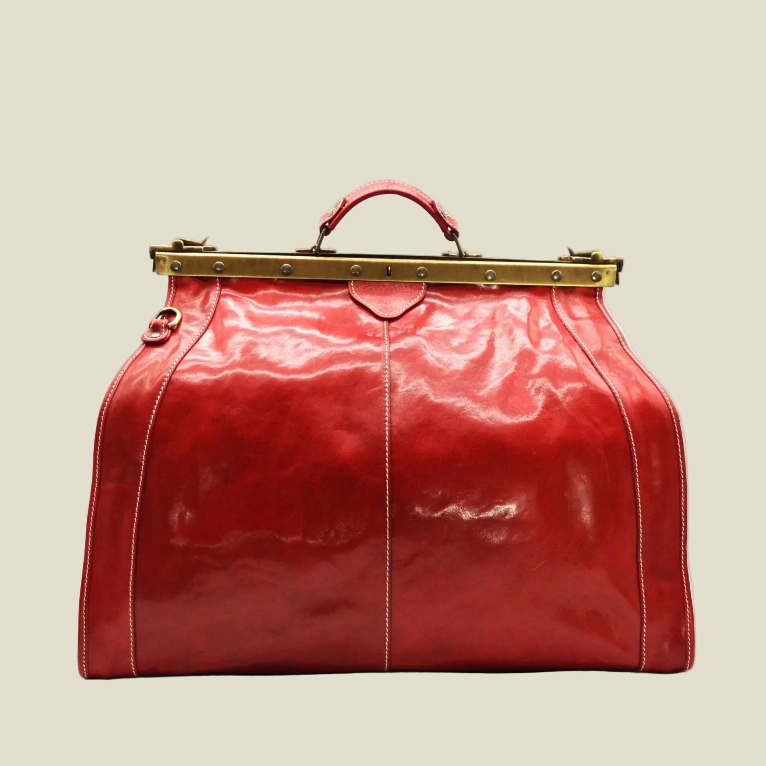 A glossy red leather top-handle satchel bag with a gold-tone metal frame clasp closure, shown against a plain white background.