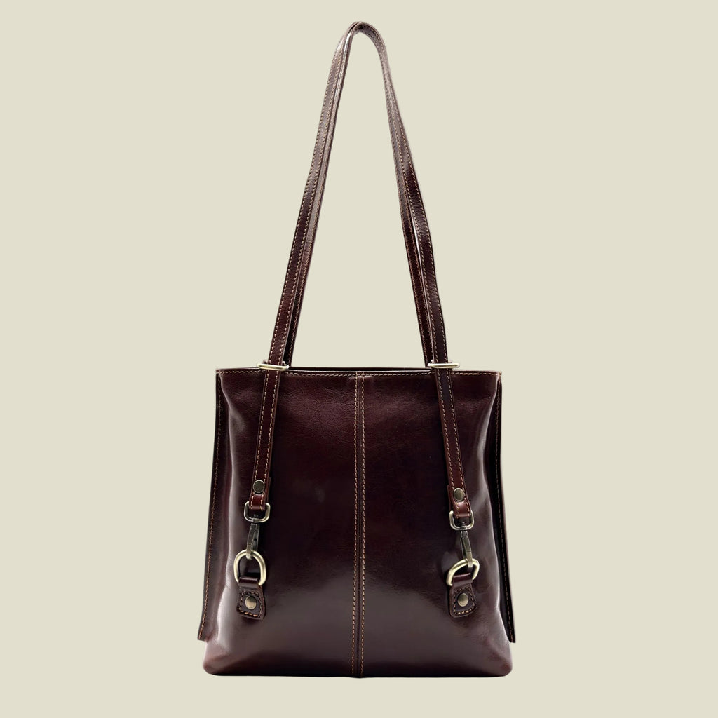 A dark burgundy leather tote bag with double shoulder straps, gold-tone hardware, and decorative leather loops on the front, shown against a plain white background.
