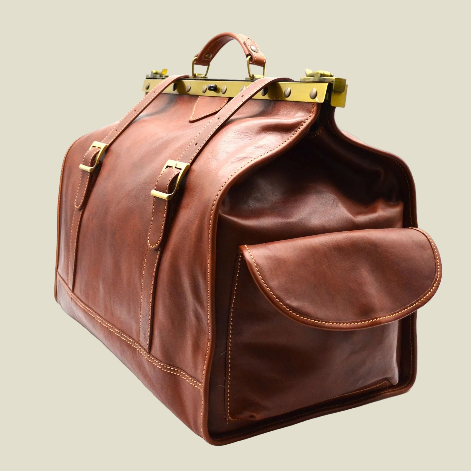 Brown leather bag with gold accents on a beige background