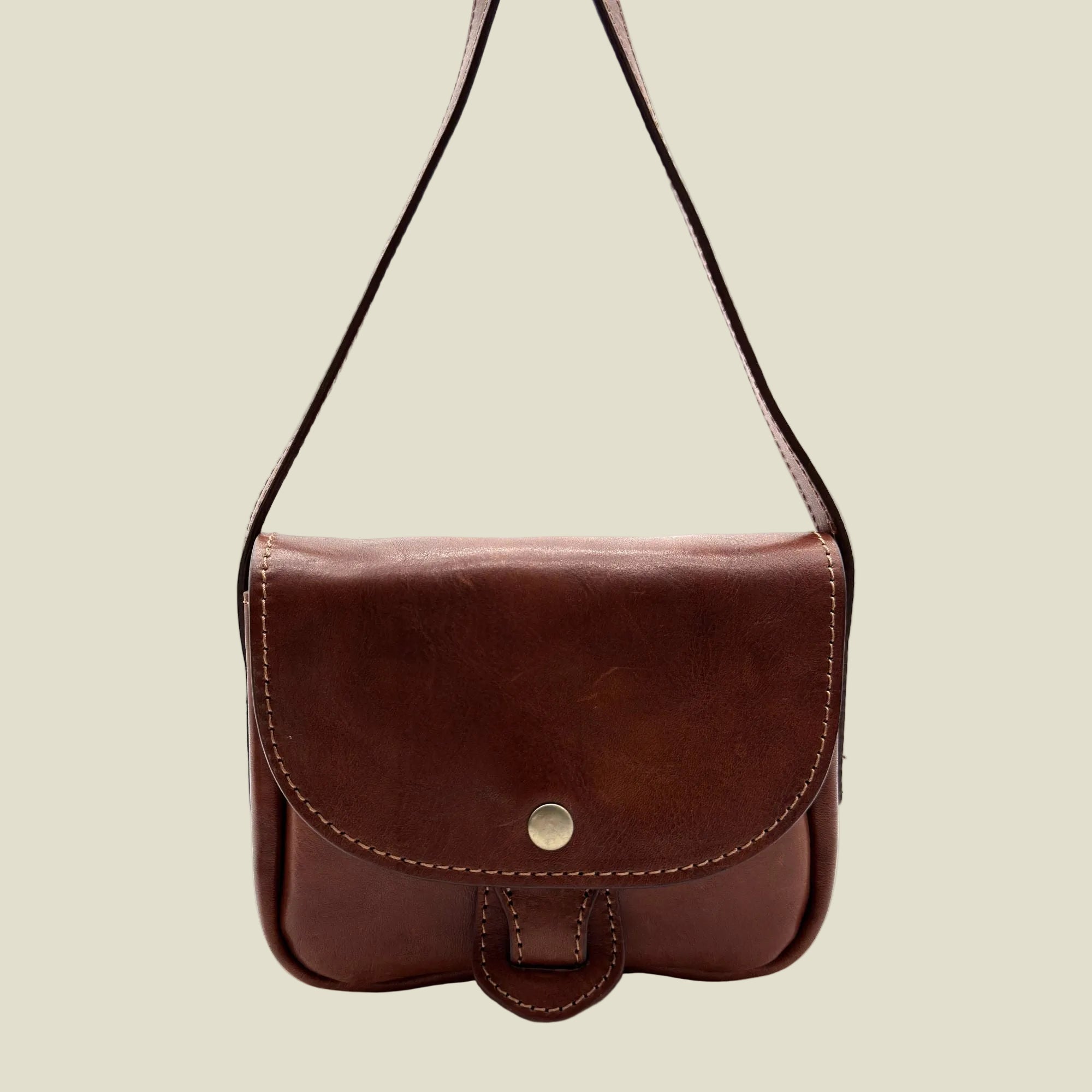 A brown leather shoulder bag with a flap closure and a single metal snap button, shown against a plain white background.