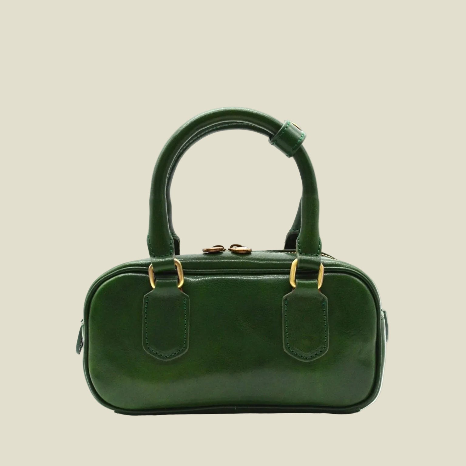 A dark green leather handbag with a rounded rectangular body, double top handles, and gold-tone hardware, shown against a plain white background.