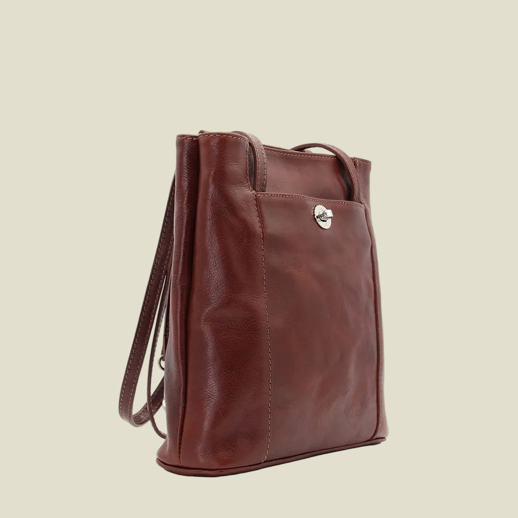 A brown leather tote bag with a top handle and a shoulder strap, shown from a three-quarter angle against a plain white background.