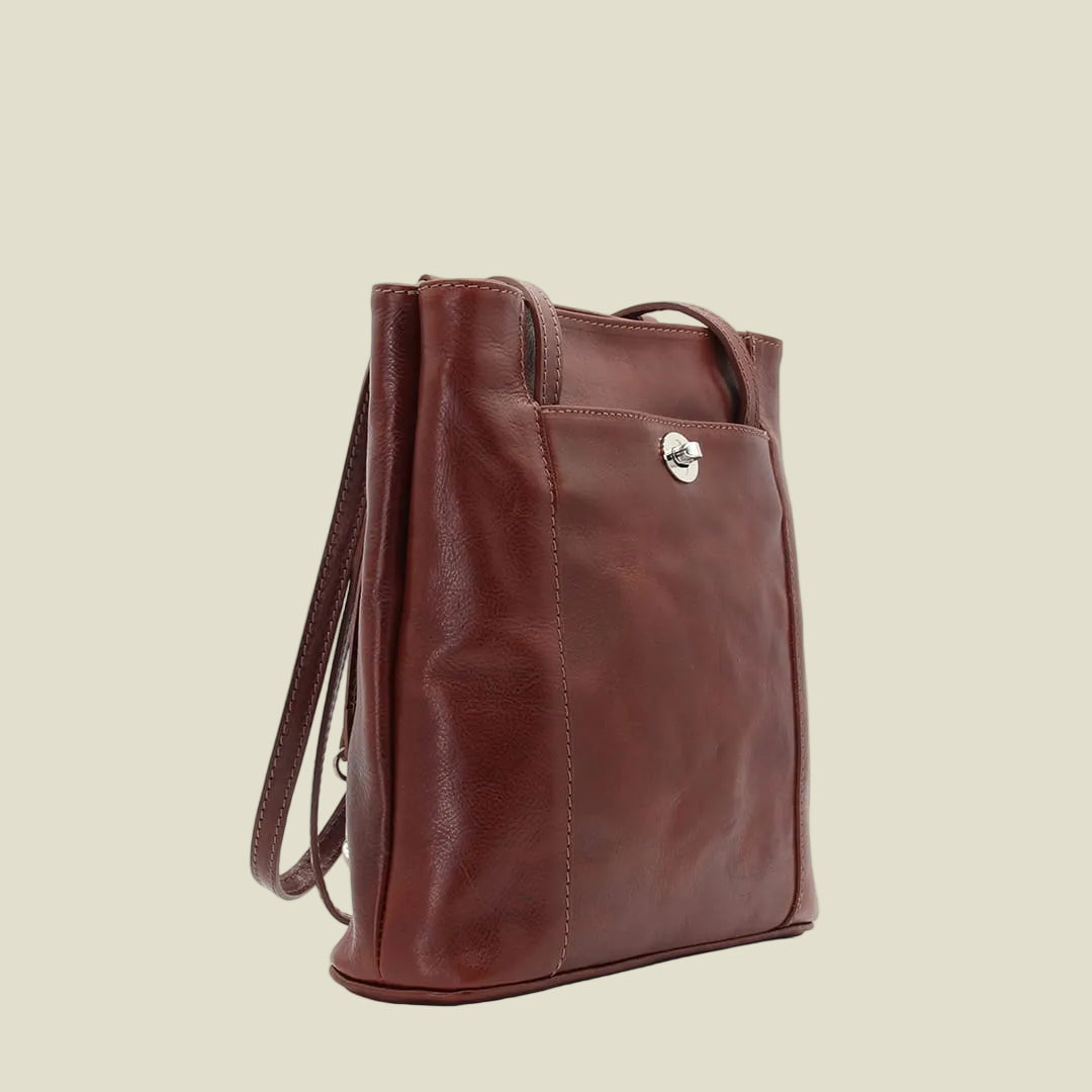 A brown leather tote bag with a top handle and a shoulder strap, shown from a three-quarter angle against a plain white background.