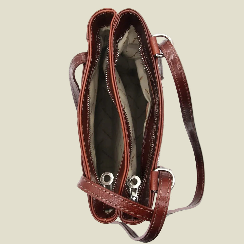 A brown leather crossbody handbag shown from an overhead angle, displaying its interior compartments, silver-tone hardware, and a matching adjustable shoulder strap against a plain white background.