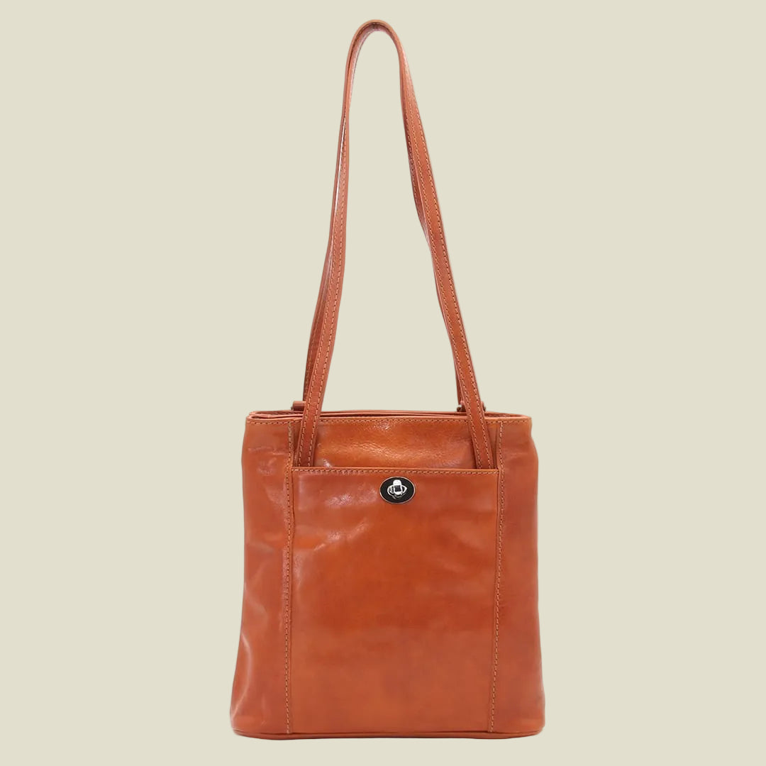 A brown leather tote bag with a single shoulder strap and a small silver-tone logo button on the front pocket, shown against a plain white background.
