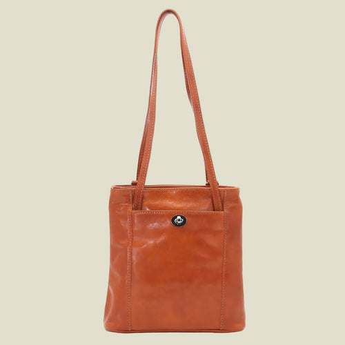 A brown leather tote bag with a single shoulder strap and a small silver-tone logo button on the front pocket, shown against a plain white background.