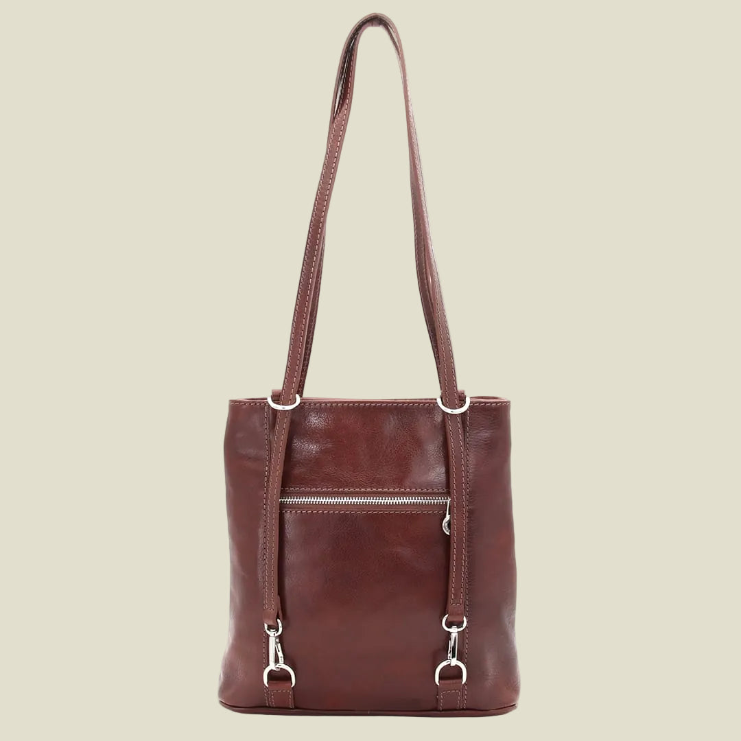 A dark reddish-brown leather tote bag with a single shoulder strap, a front zippered pocket, and silver-tone hardware, shown against a plain white background.