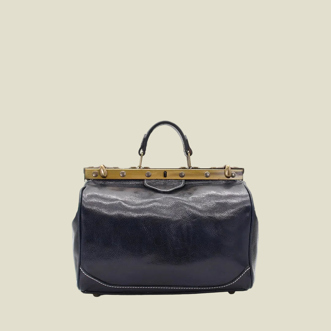 A dark navy blue leather handbag with a gold-tone metal frame and top handle, photographed against a plain white background.