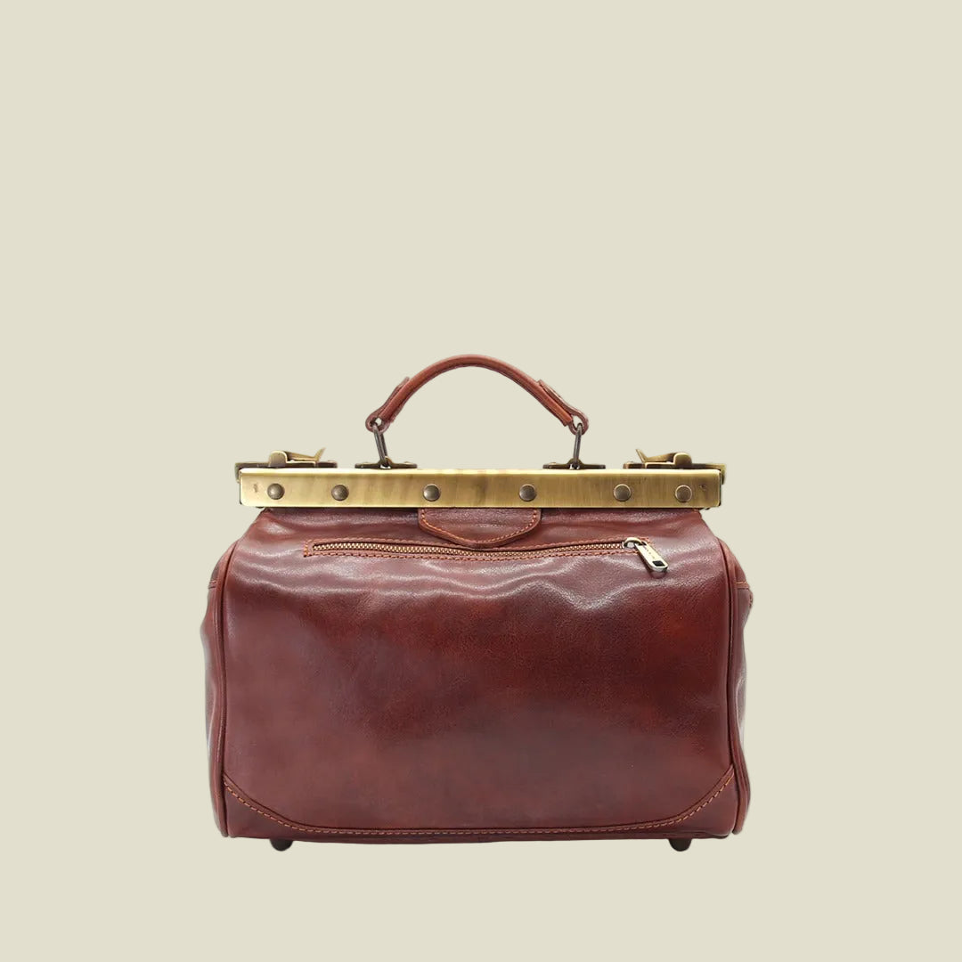 A vintage-style leather doctor bag in reddish-brown with a gold-tone metal frame and handle, shown against a plain white background.