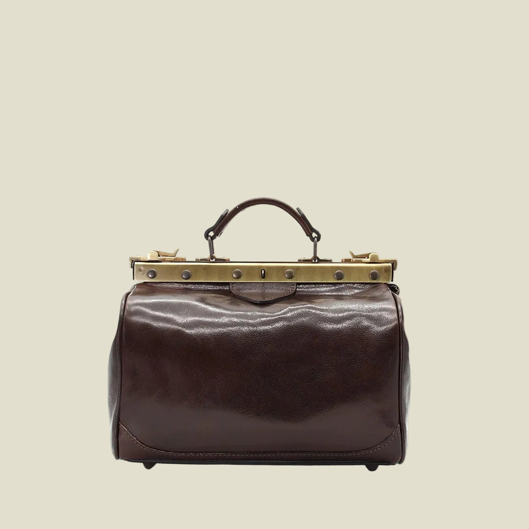 A dark brown leather satchel handbag with a gold-tone metal frame and top handle, shown against a plain white background.