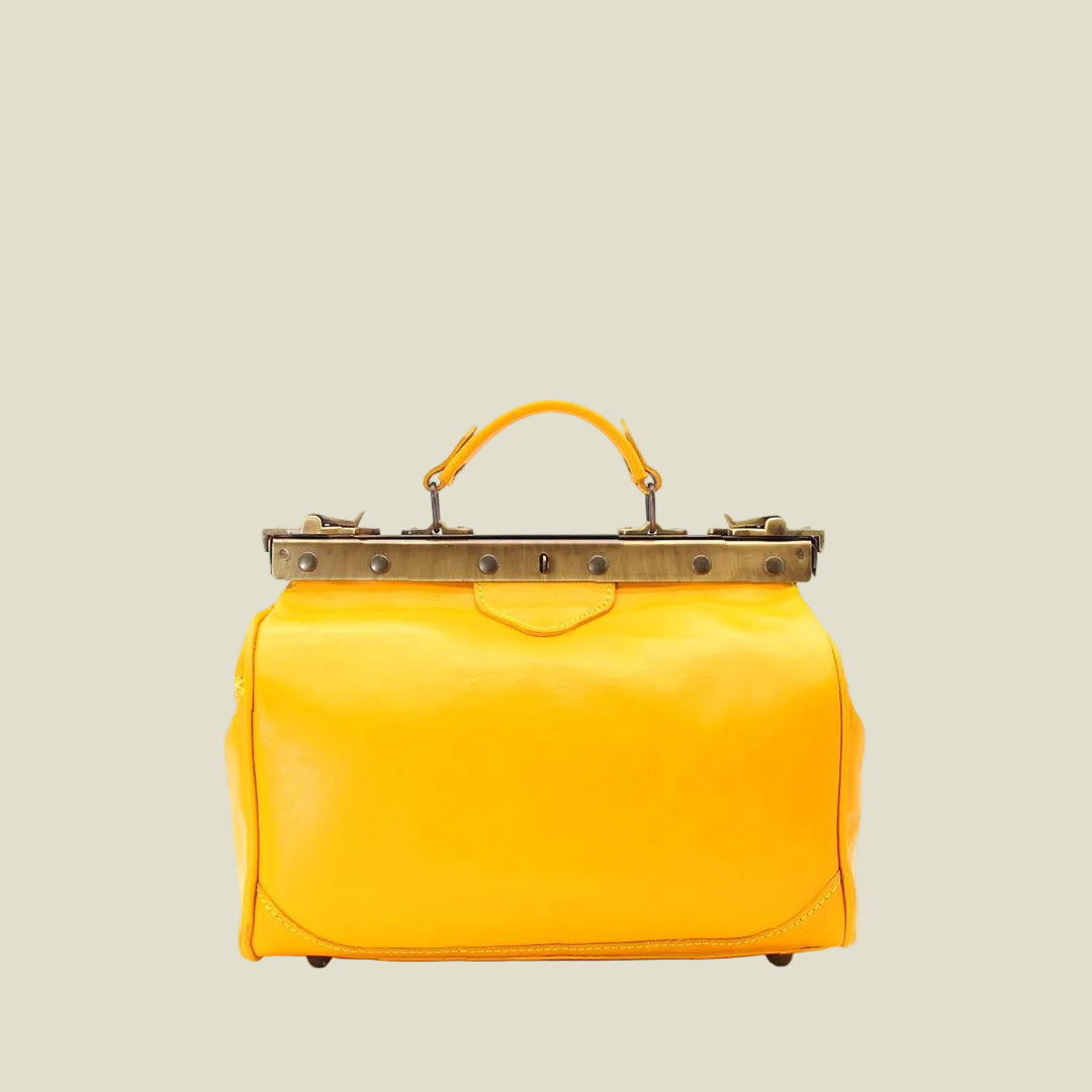 A bright yellow leather handbag with a top handle and a bronze-tone metal frame clasp, shown against a plain white background.