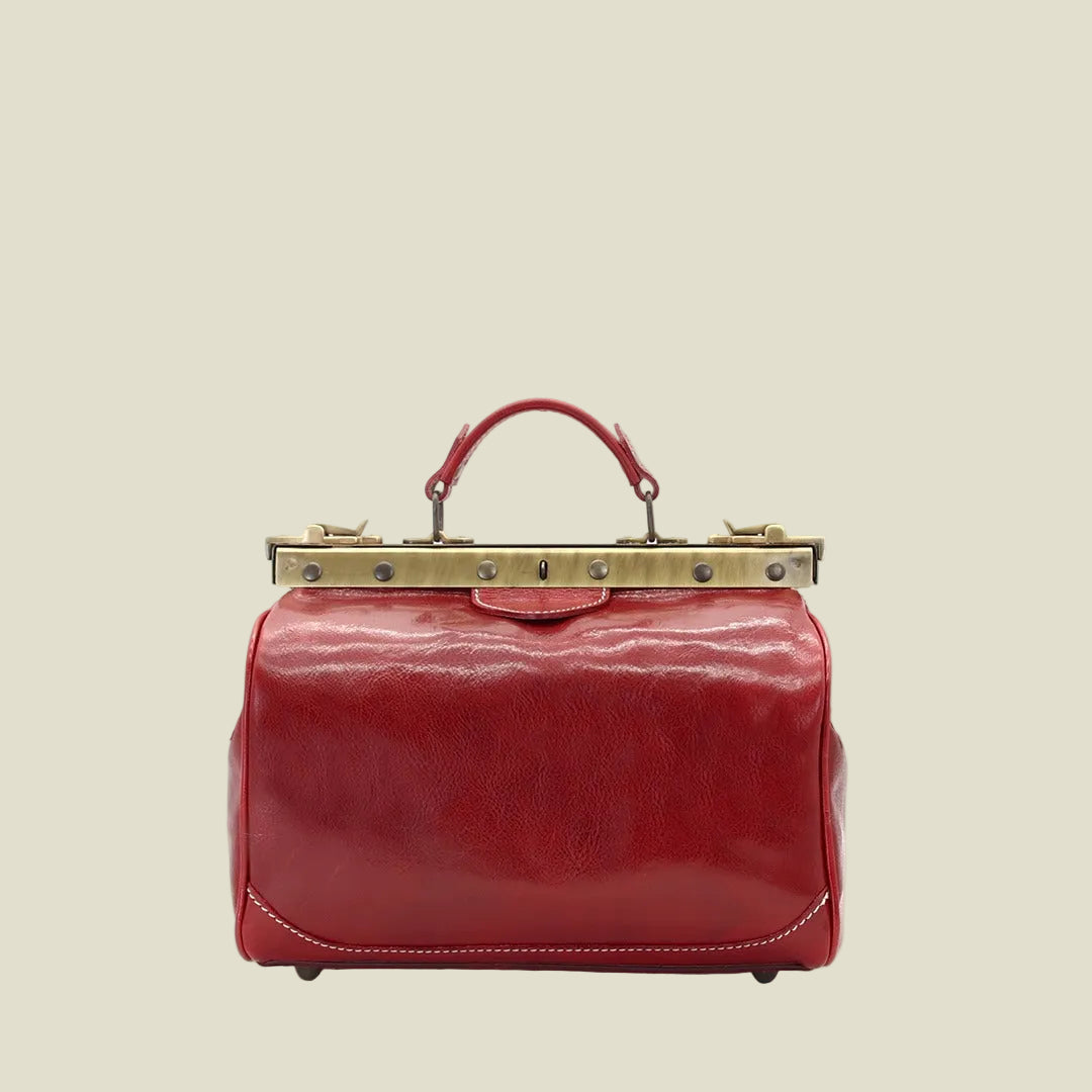 A red patent leather handbag with a top handle and a gold-tone metal frame clasp, shown against a plain white background.