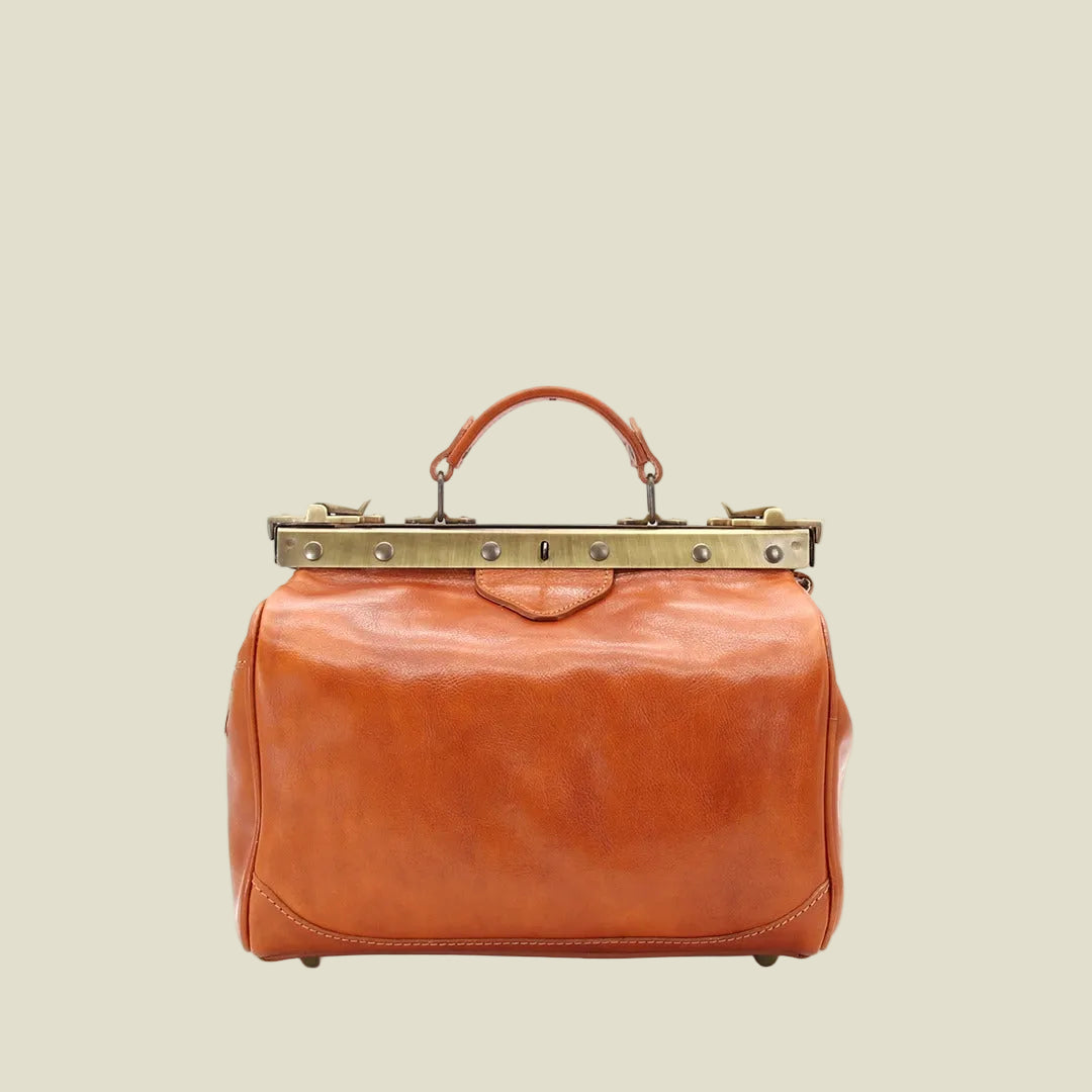 A vintage-style leather doctor's bag in a warm cognac brown, featuring a top handle, brass-tone metal frame, and rivets, shown against a plain white background.