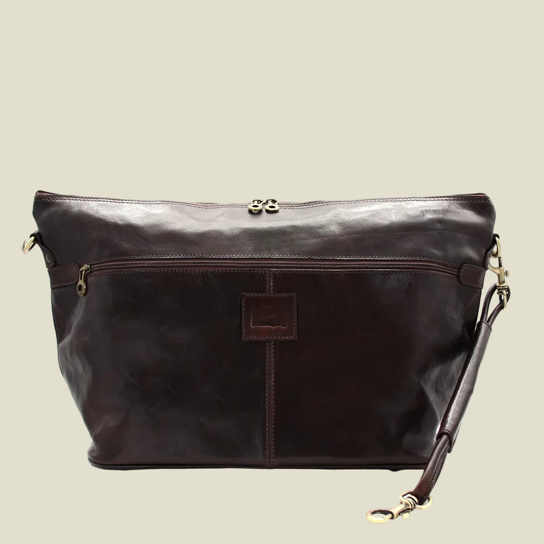 A dark brown leather shoulder bag with a front zippered pocket, a central vertical seam, and gold-tone hardware, shown against a plain white background.