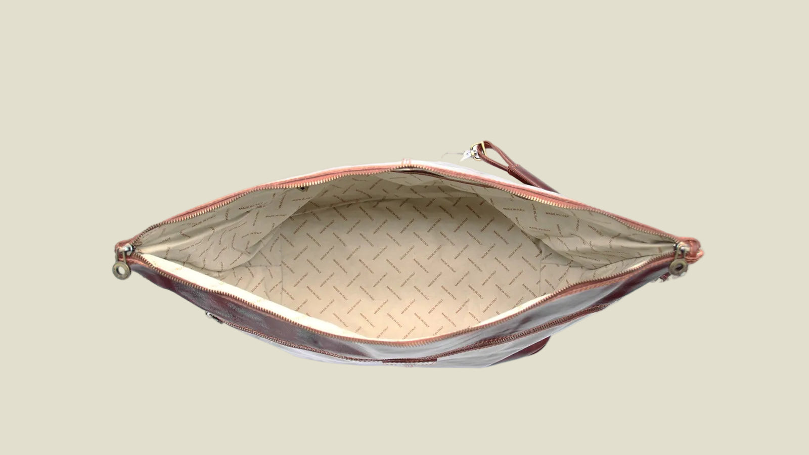 An open zippered clutch or pouch shown from above, featuring a beige patterned interior lining and a dark brown exterior with a matching wrist strap, set against a plain white background.
