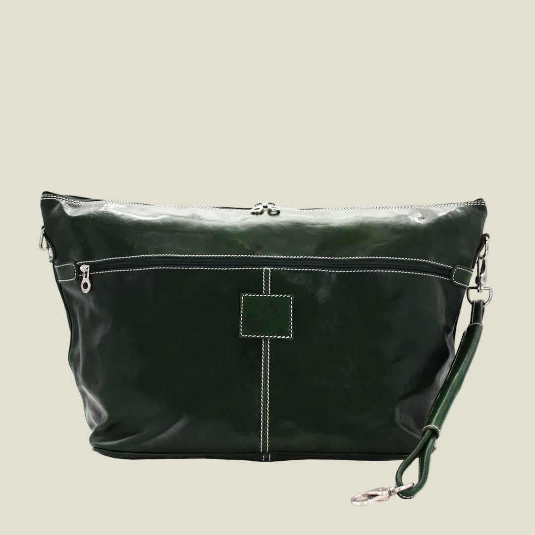 A dark green leather shoulder bag with white contrast stitching, a top zipper, and a detachable wristlet strap, shown against a plain white background.