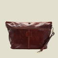 A dark reddish-brown leather shoulder bag with a front zippered pocket, a central vertical seam, and gold-tone hardware, shown on a plain white background.