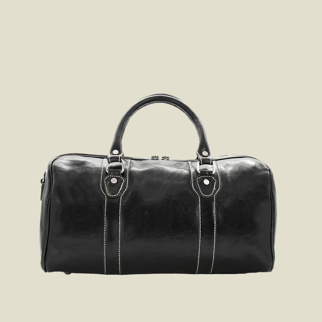 A black leather duffel bag with a glossy finish, featuring dual top handles, silver-tone hardware, and white contrast stitching details, shown against a plain white background.