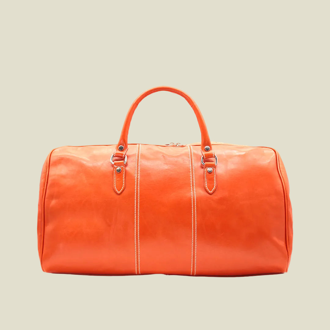 An orange leather duffel bag with dual top handles, silver-tone hardware, and contrasting light stitching, shown against a plain white background.