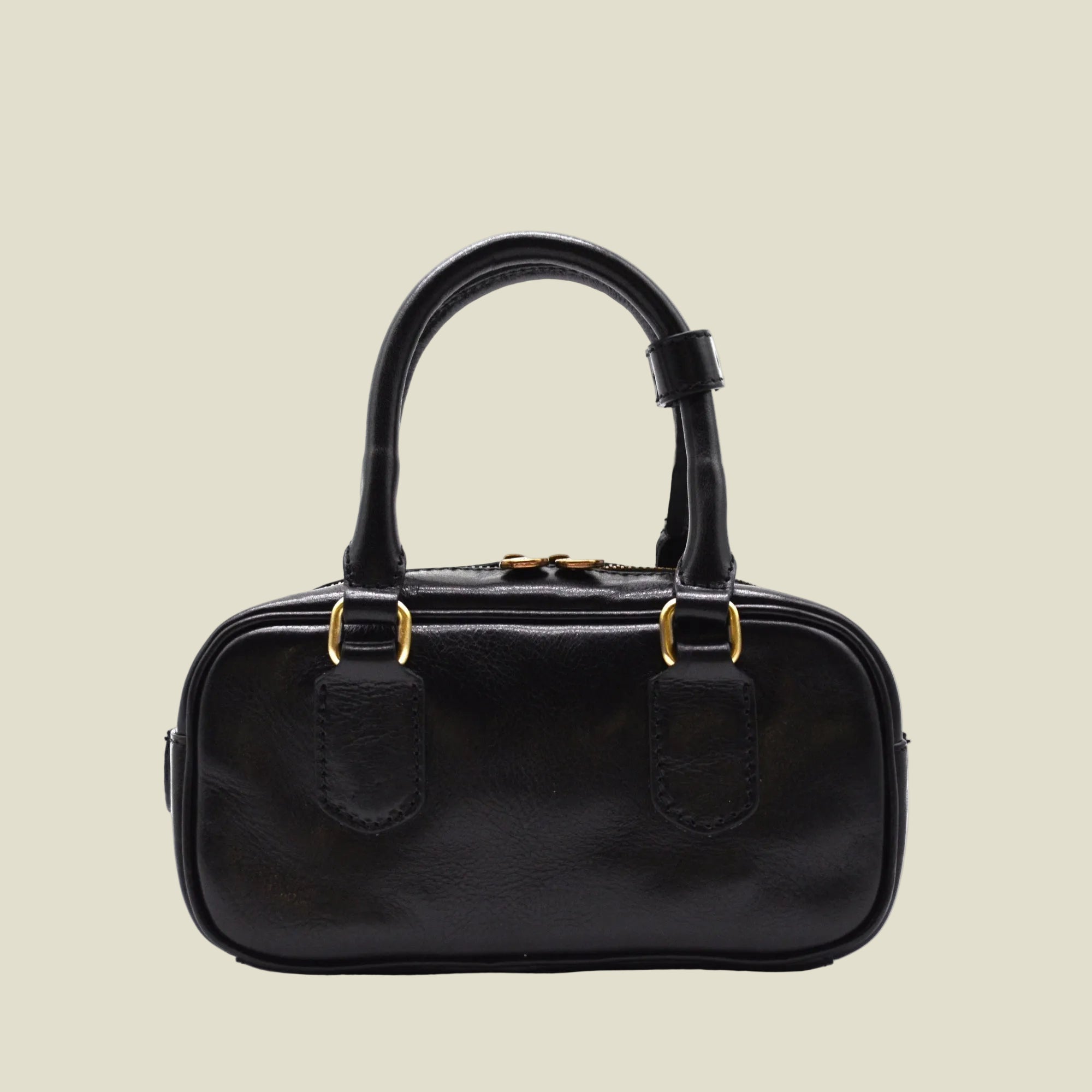 A black leather handbag with a structured oval shape, dual top handles, and gold-tone hardware, shown against a plain white background.