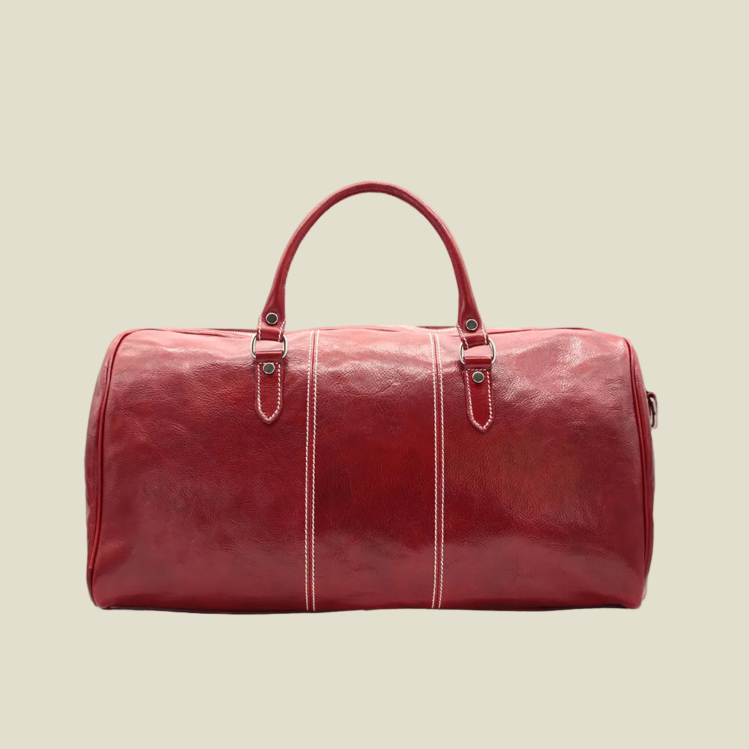 A red leather duffel bag with dual top handles, decorative white contrast stitching, and silver-tone hardware, shown against a plain white background.